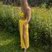 Nikkey, a Madison escort, standing outdoors in a bright yellow outfit.