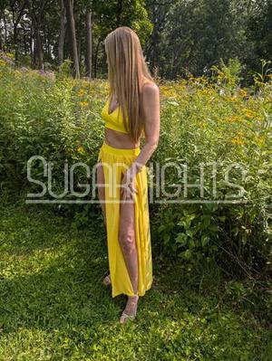 Nikkey, a Madison escort, standing outdoors in a bright yellow outfit. Nikkey, a Madison escort, standing outdoors in a bright yellow outfit.